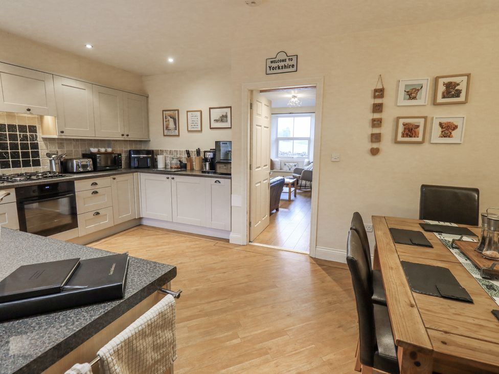 A kitchen with a dining table and chairs at Old Bridge Inn Ingleton