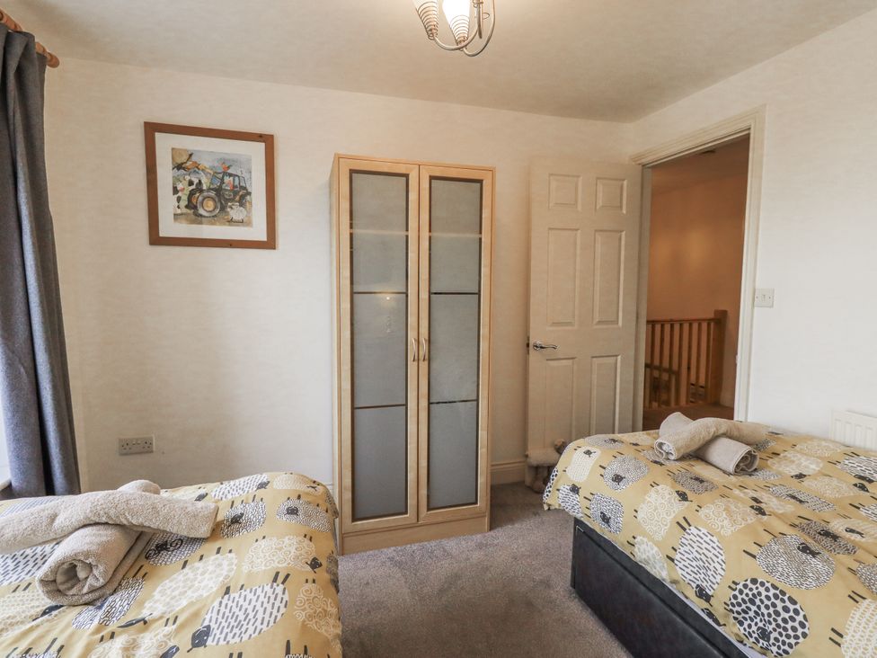 A bedroom with two beds and a wardrobe at Old Bridge Inn Ingleton
