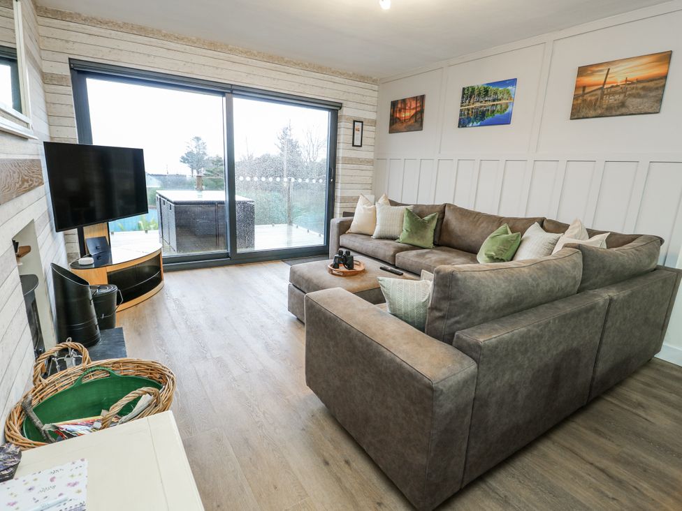 A living room with a sofa and a television at Daisy Cottage in Benllech