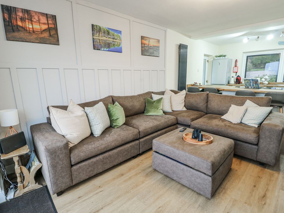 A living room with a sofa and coffee table at Daisy Cottage in Benllech