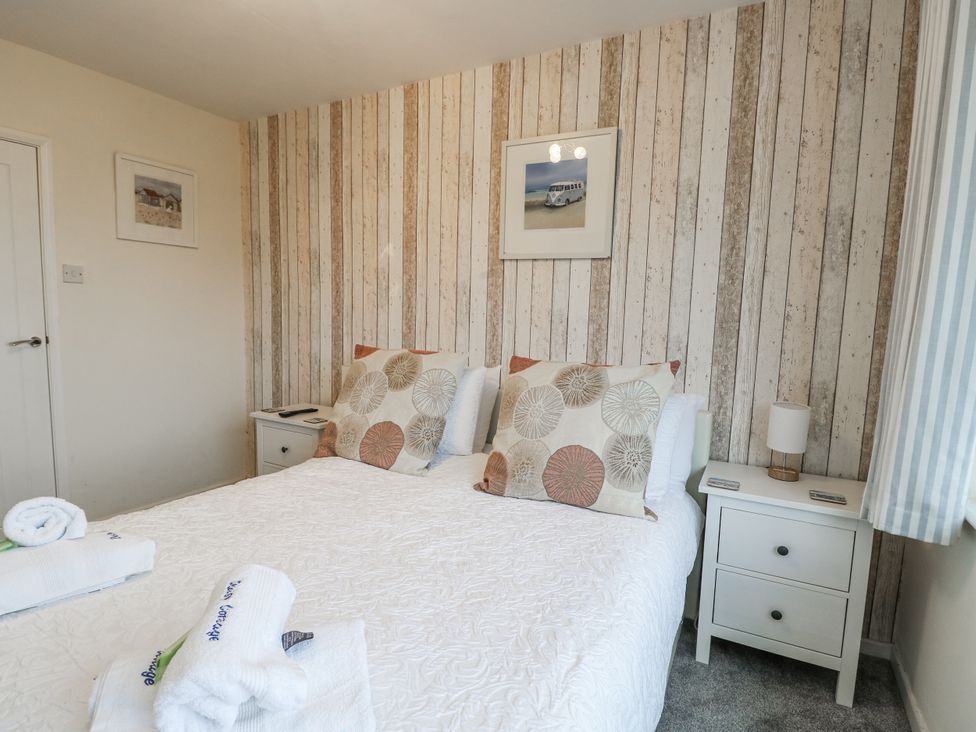 A bedroom with a double bed and nightstands at Daisy Cottage in Benllech