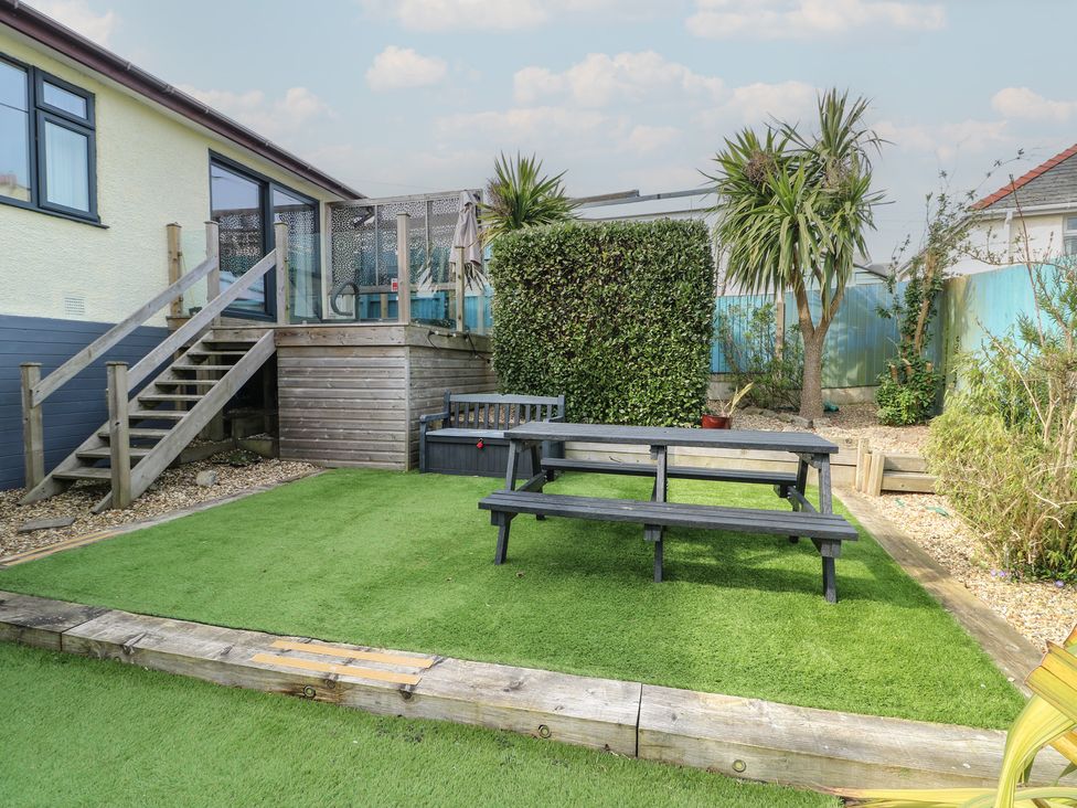 A garden with a table and steps at Daisy Cottage Benllech