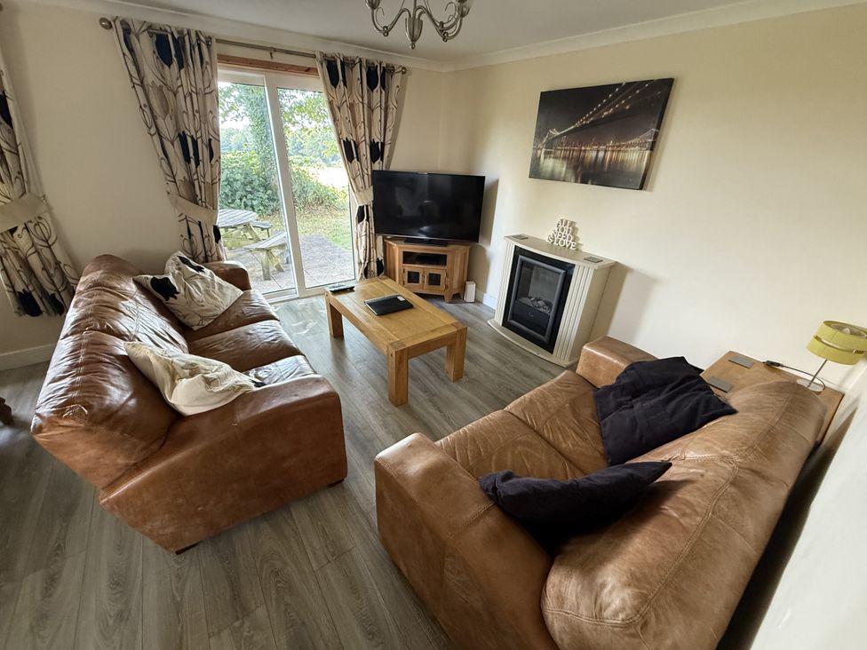 A living room with sofas and a television at Hembry Meadows in Honicombe Park near Gunnislake