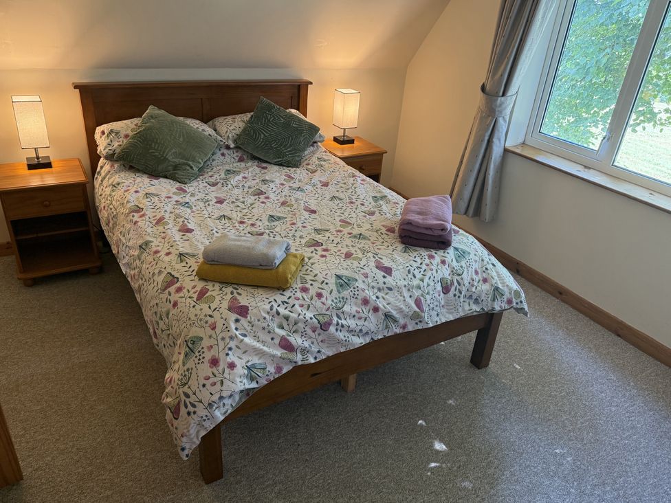 A bedroom with a bed and bedside tables at Hembry Meadows Honicombe Park near Gunnislake