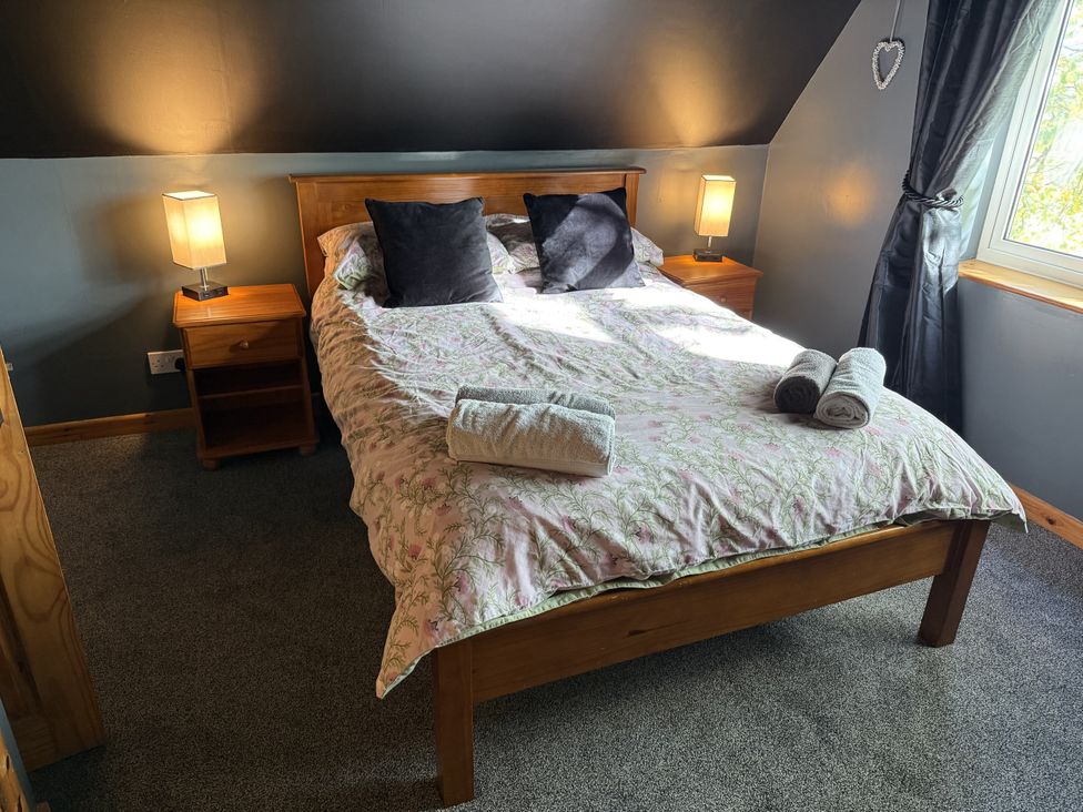 A bedroom with a bed and bedside table at Hembry Meadows Honicombe Park near Gunnislake