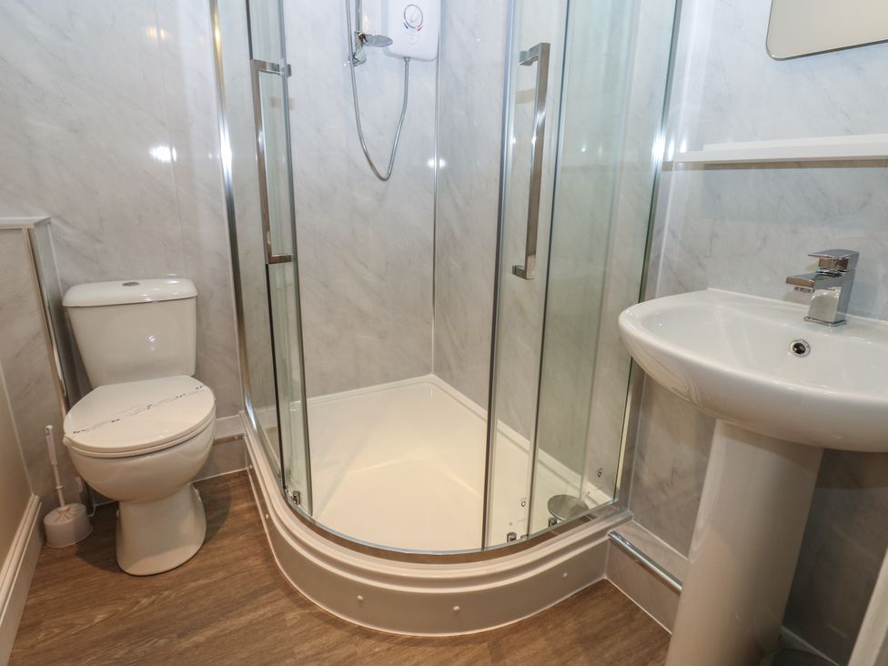 A bathroom with a shower, toilet, and sink at Lavender Cottage in Richmond