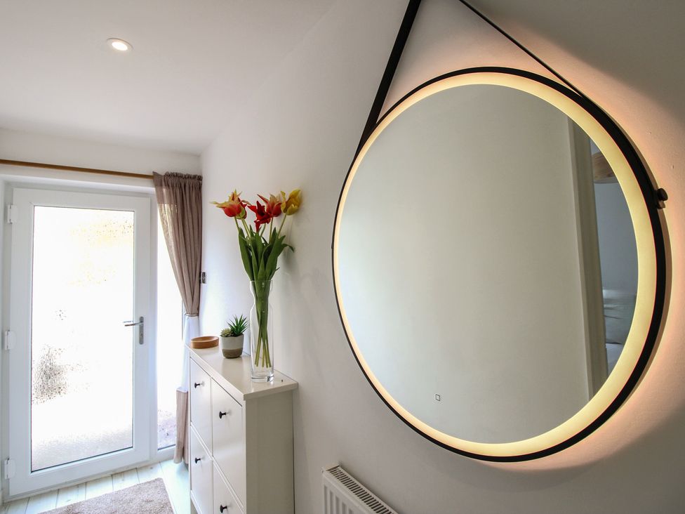 A hallway with a mirror and flower vase at Little Starboard in Kingsbridge