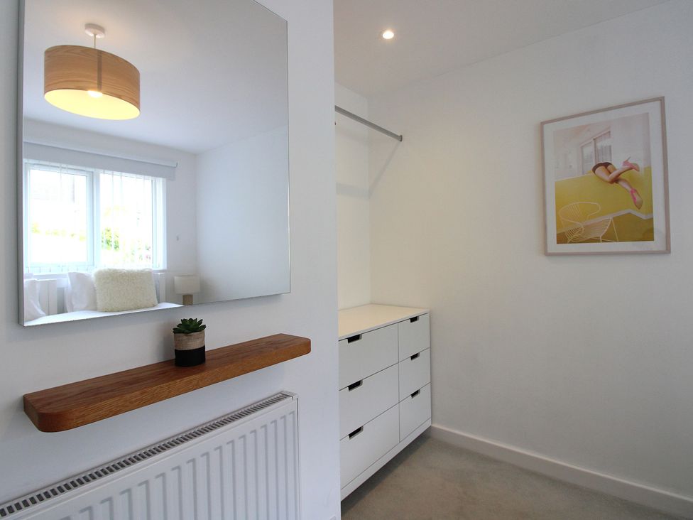 A bedroom with a mirror and drawer unit at Little Starboard in Kingsbridge