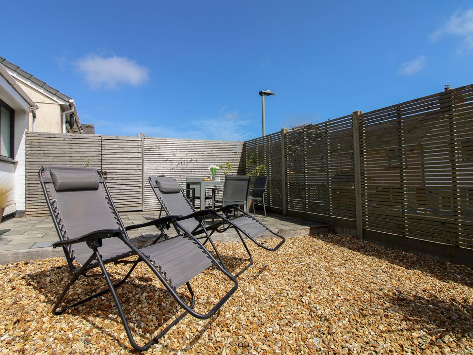A garden with deck chairs and a table at Little Starboard in Kingsbridge