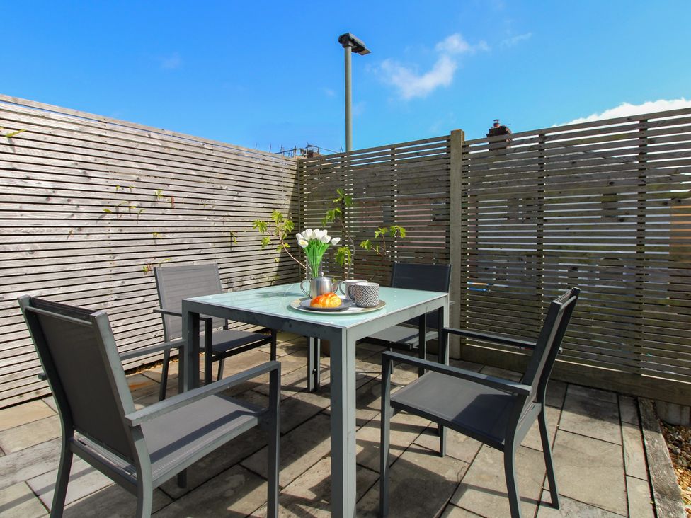 An outdoor seating area with a table and chairs at Little Starboard in Kingsbridge
