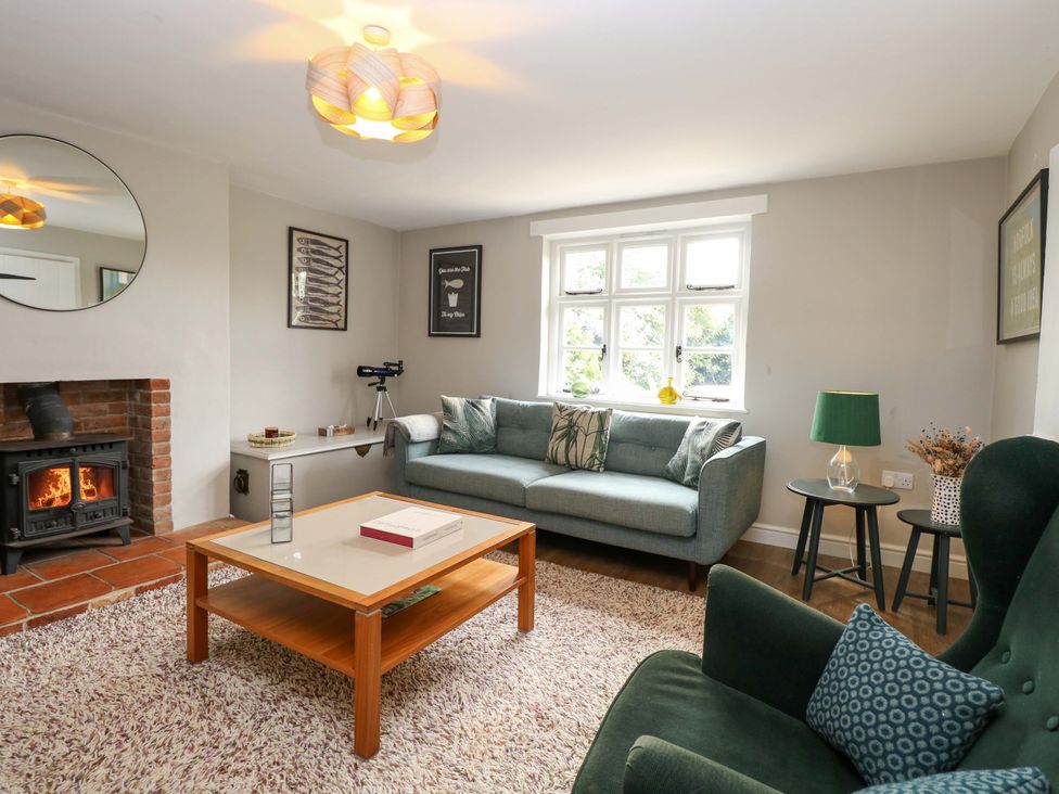 A living room with a sofa and coffee table at The Mallows in Walsingham