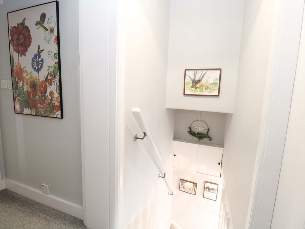 A staircase with wall art and a decorative sign at The Mallows in Walsingham