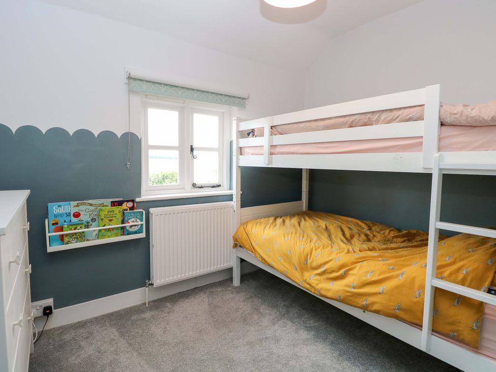 A bedroom with a bunk bed and bookshelf The Mallows Walsingham