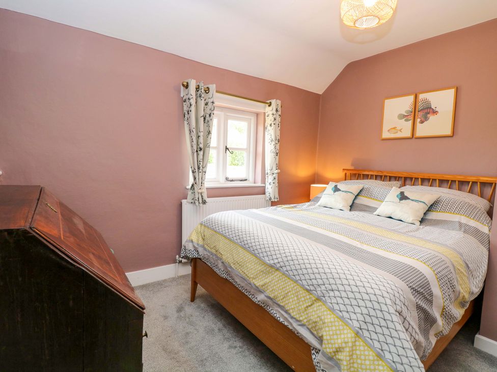 A bedroom with a bed, pillows, and a window at The Mallows in Walsingham