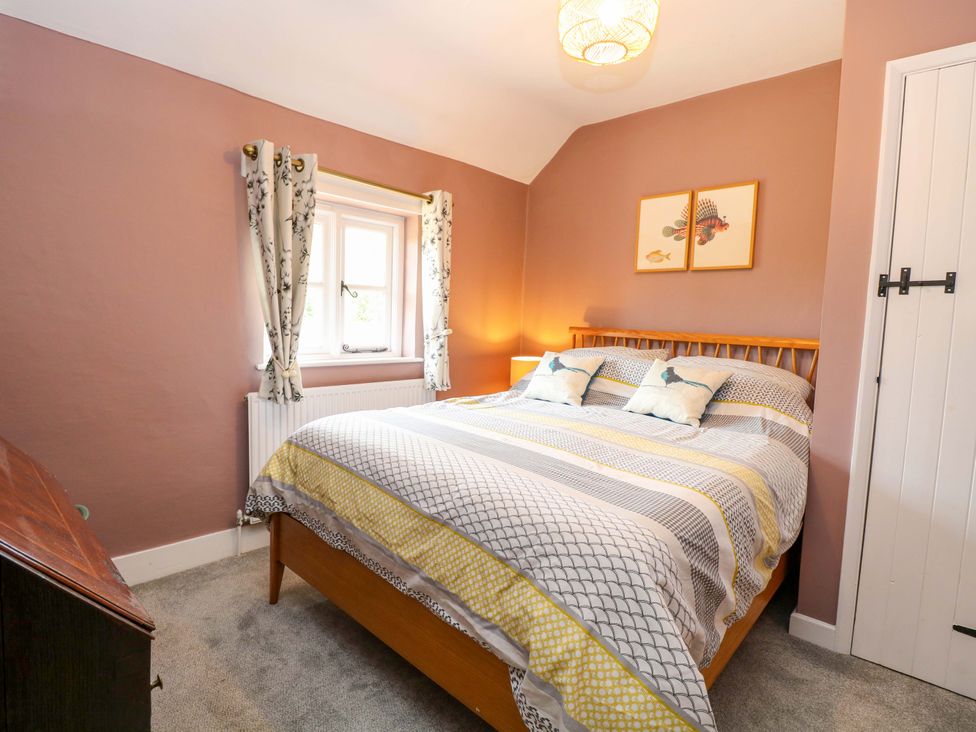 A bedroom with a bed and nightstand at The Mallows in Walsingham