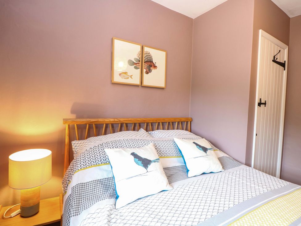 A bedroom with a bed and artwork on the wall at The Mallows in Walsingham