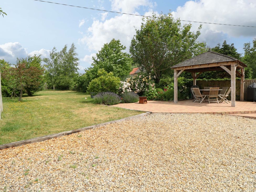 A garden with a gazebo and gravel area at The Mallows in Walsingham