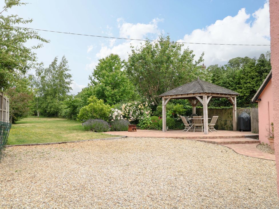 A garden with a gazebo and seating area at The Mallows in Walsingham