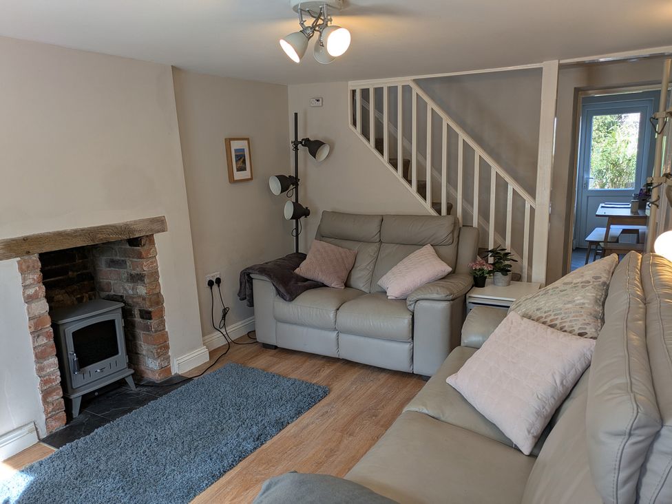 A living room with a fireplace and sofa at Melita in Curry Rivel