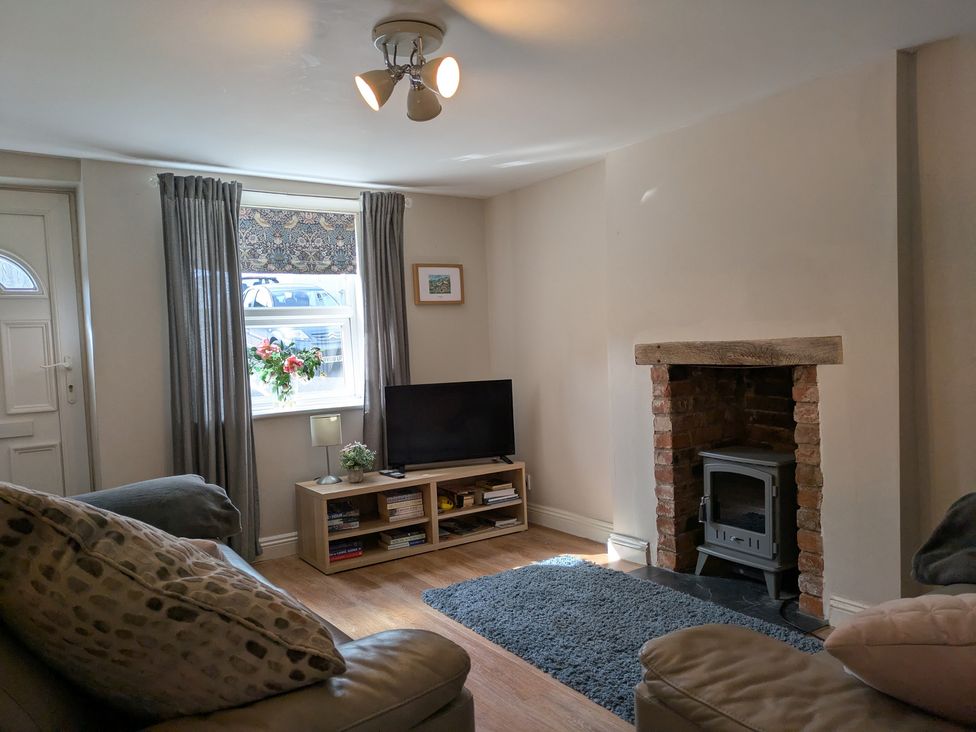 A living room with a television and fireplace at Melita in Curry Rivel