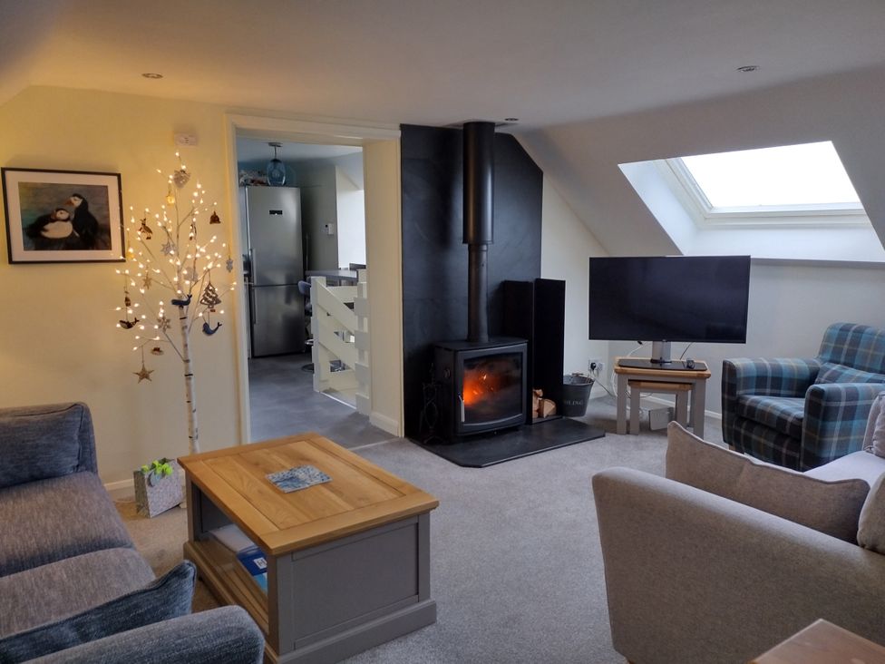 A living room with a fireplace and television at Coast View in Hartland