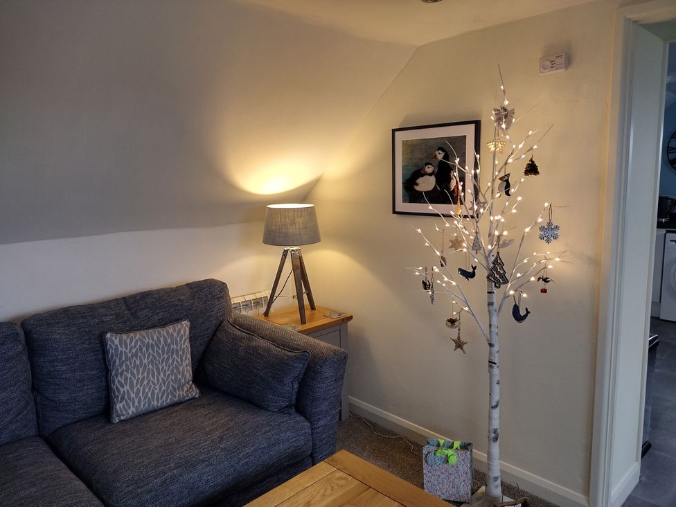 A living room with a couch and decorative tree at Coast View in Hartland