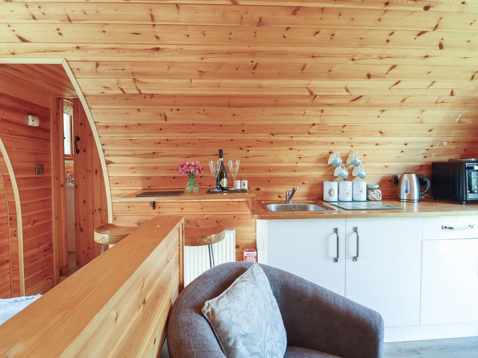 A kitchen with wooden walls and furniture at Embden Pod at Banwy Glamping Llanfair Caereinion