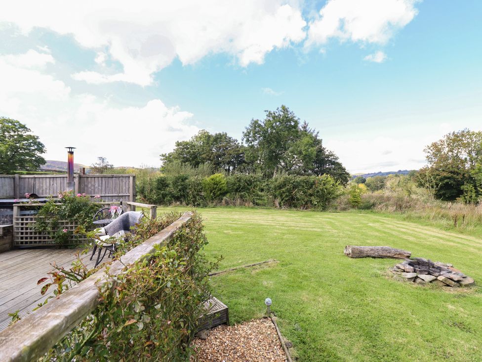A garden with a fire pit and seating area at Embden Pod at Banwy Glamping in Llanfair Caereinion