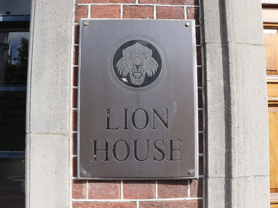 A plaque with 'LION HOUSE' and a lion head displayed at Lion House in Moretonhampstead