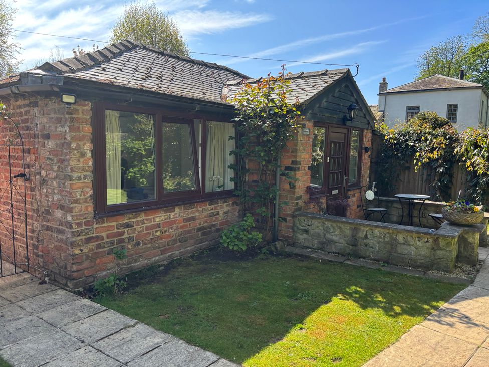 An outdoor area with a brick building and seating at Claire Cottage in Gateforth near Hambleton, North Yorkshire