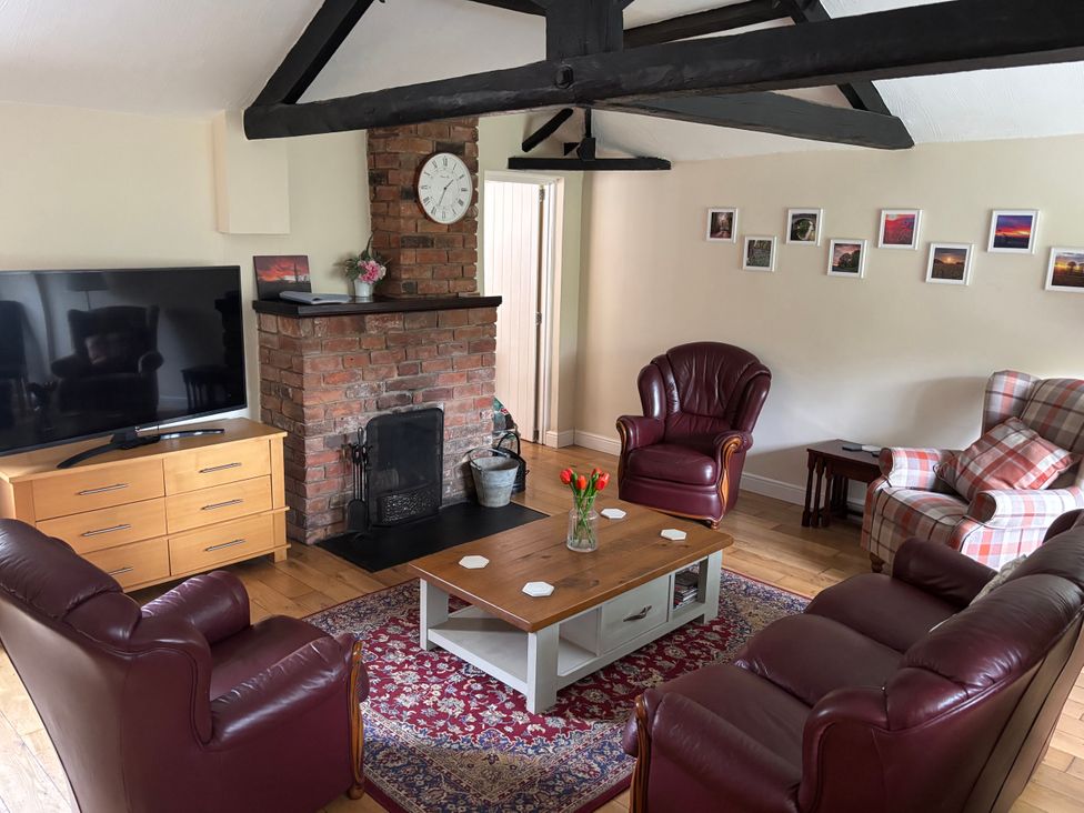 A living room with a television and a fireplace at Claire Cottage, Gateforth near Hambleton, North Yorkshire