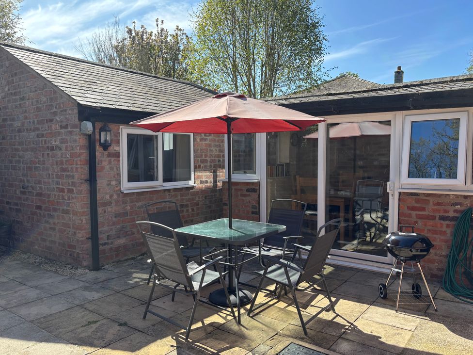 An outdoor area with a table and chairs at Claire Cottage, Gateforth near Hambleton, North Yorkshire