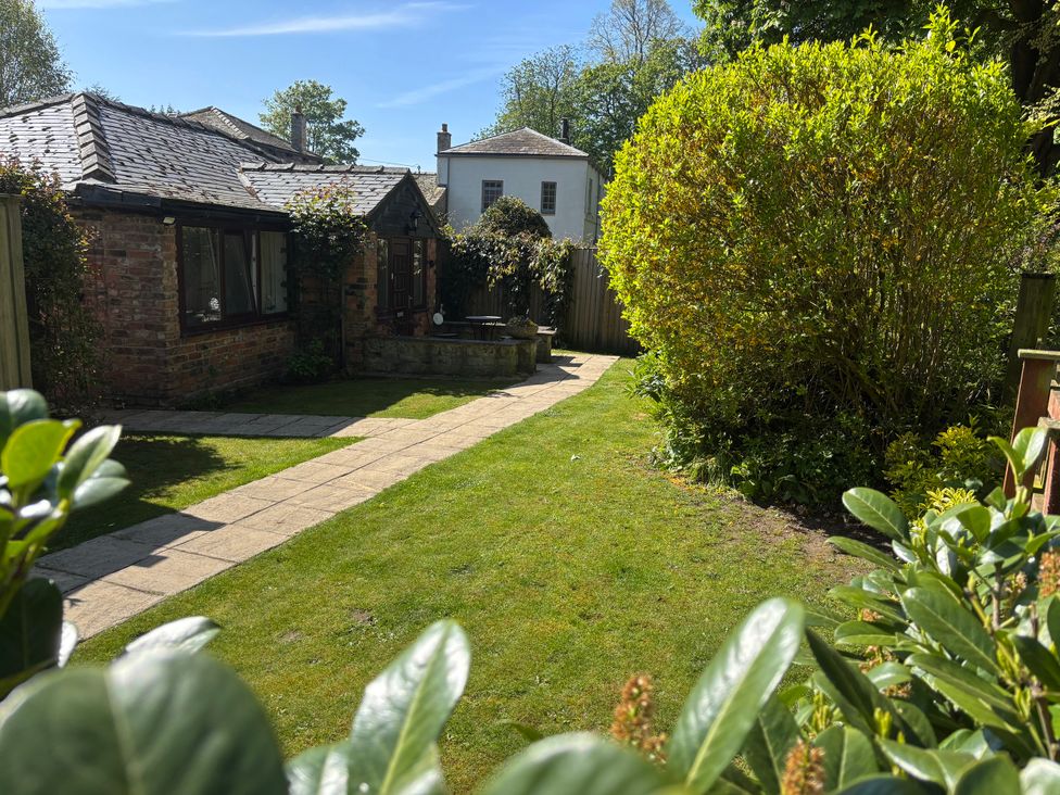 A garden with a pathway and house at Claire Cottage Gateforth near Hambleton, North Yorkshire