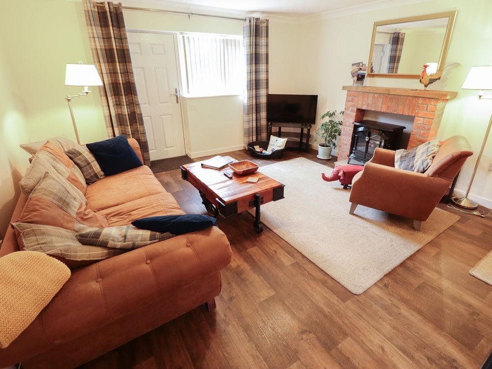 A living room with a sofa and armchair at Marsh View Cottage in Wainfleet All Saints