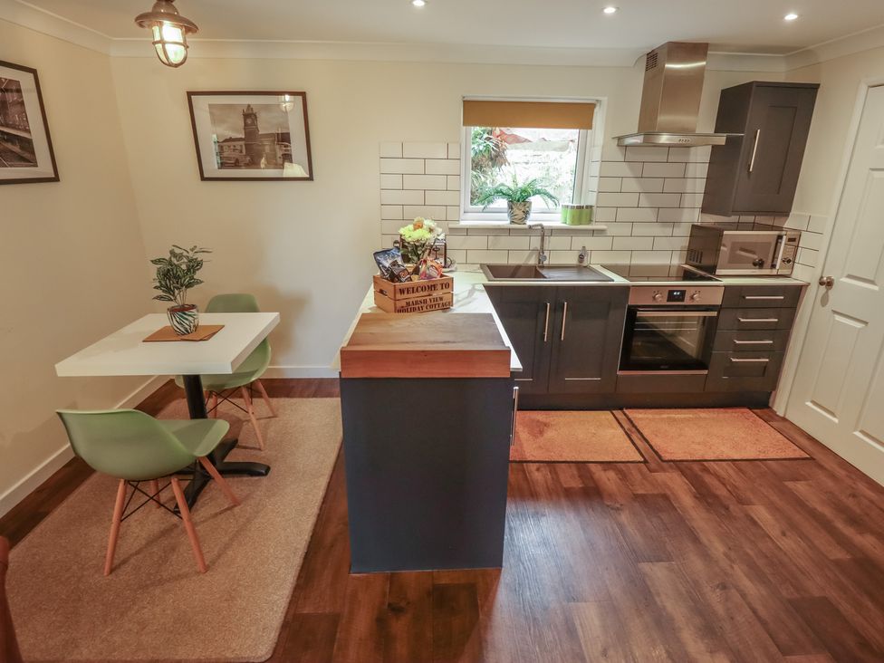 A kitchen with appliances and dining area at Marsh View Cottage Wainfleet All Saints