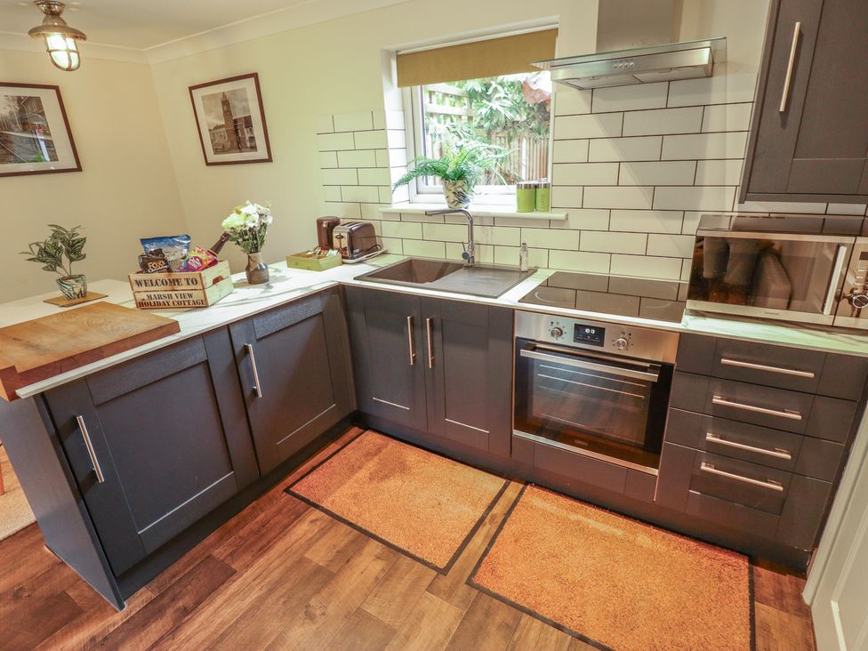A kitchen with cabinets and appliances at Marsh View Cottage in Wainfleet All Saints