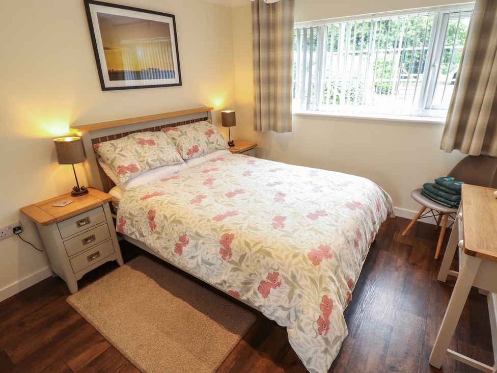 A bedroom with a bed and bedside table at Marsh View Cottage in Wainfleet All Saints