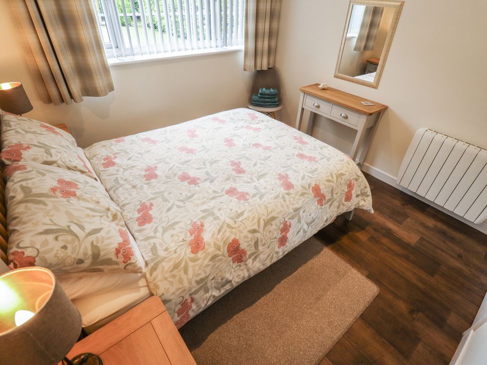 A bedroom with a bed and a mirror at Marsh View Cottage in Wainfleet All Saints