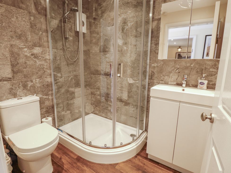 A bathroom with a shower, toilet, and vanity unit at Marsh View Cottage in Wainfleet All Saints