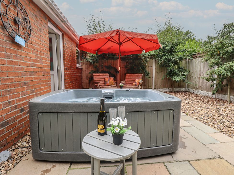 A garden with a hot tub and outdoor table at Marsh View Cottage Wainfleet All Saints