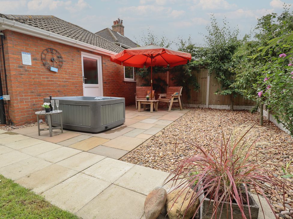 A garden with a hot tub and seating area at Marsh View Cottage in Wainfleet All Saints
