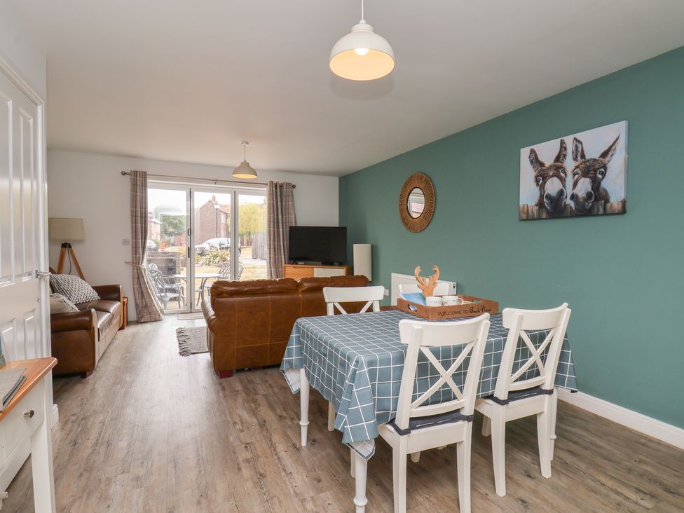 A living room with a sofa and dining area at Buck Place The Bay - Filey