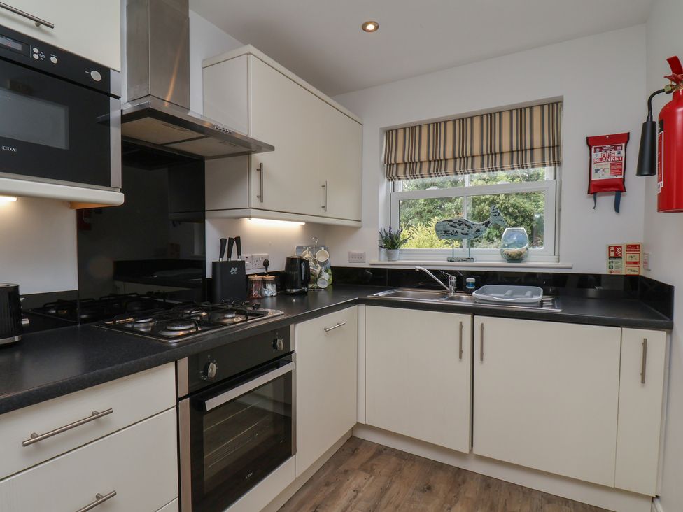 A kitchen with modern appliances and a window at Buck Place The Bay - Filey
