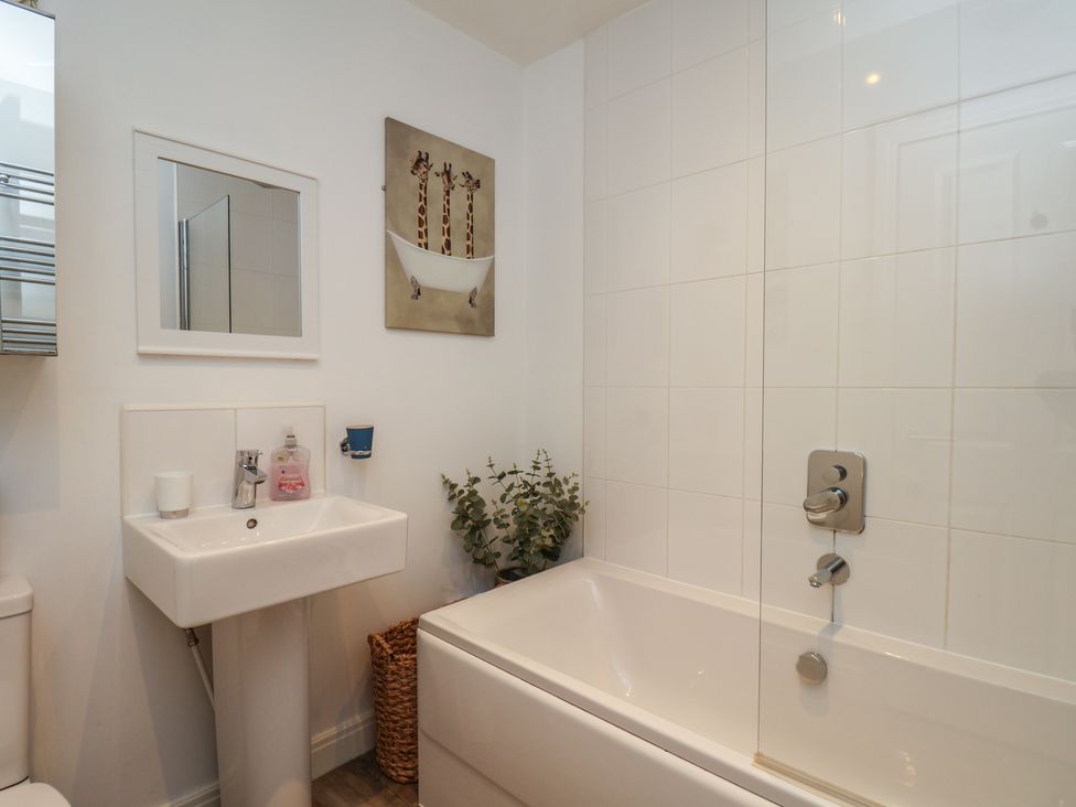 A bathroom with a bathtub and washbasin at Buck Place The Bay - Filey