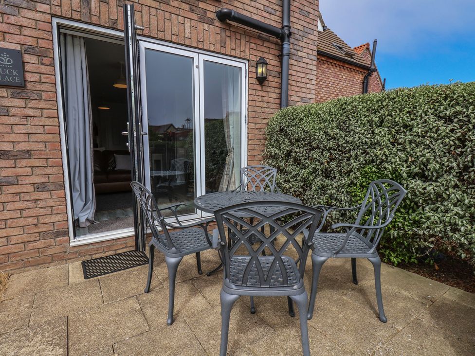 An outdoor seating area with a table and chairs at Buck Place The Bay - Filey