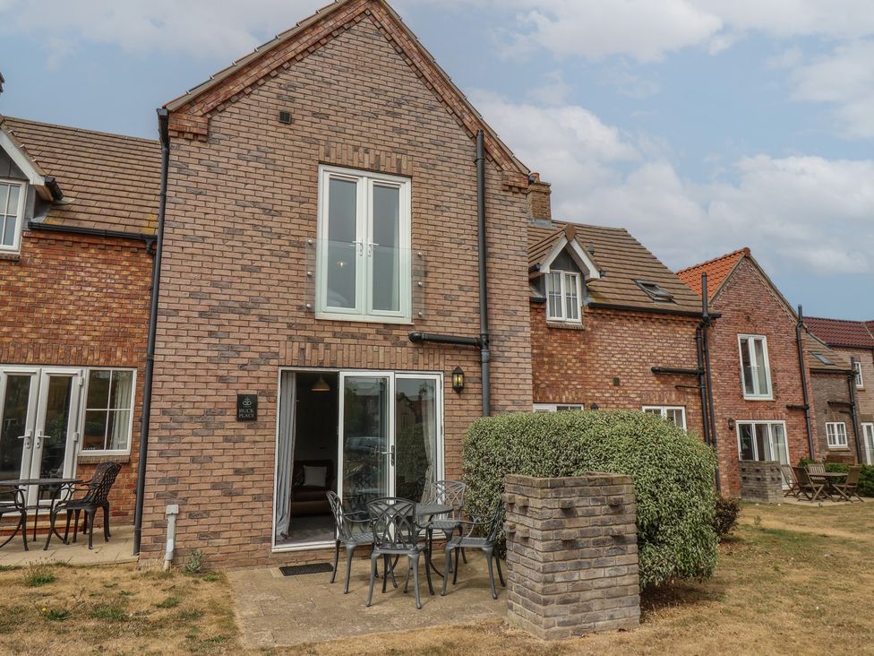 An outdoor area with seating and a brick building at Buck Place The Bay - Filey