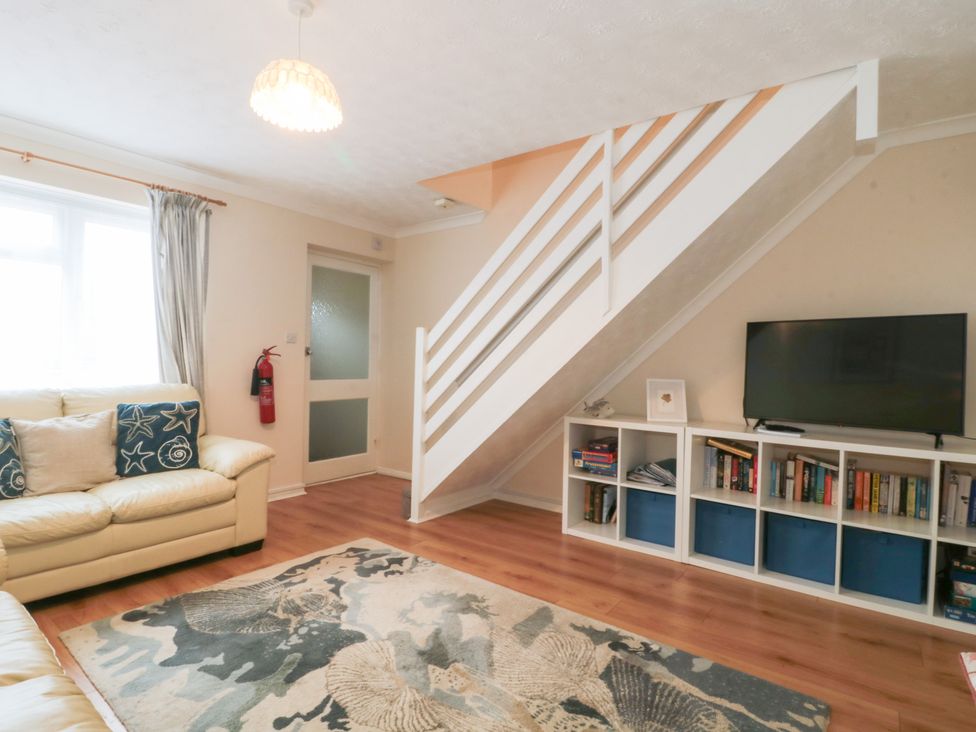A living room with a sofa and television at Jay Cottage in Weymouth