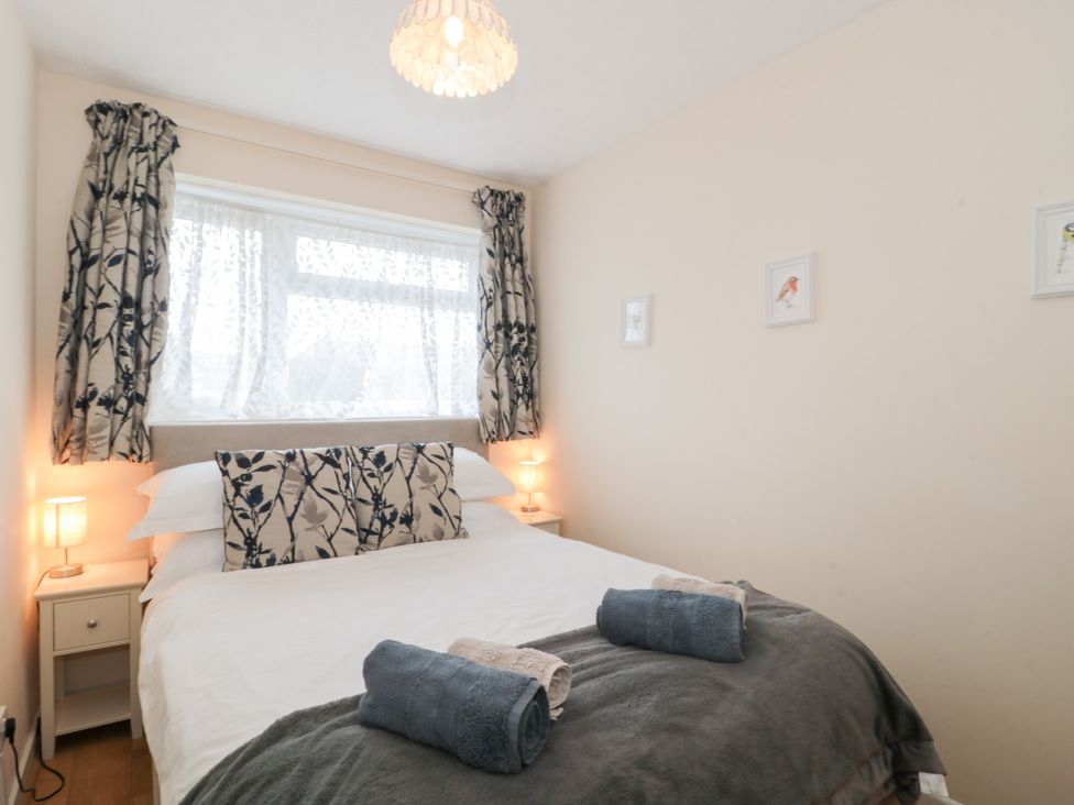 A bedroom with a bed and lamps at Jay Cottage in Weymouth