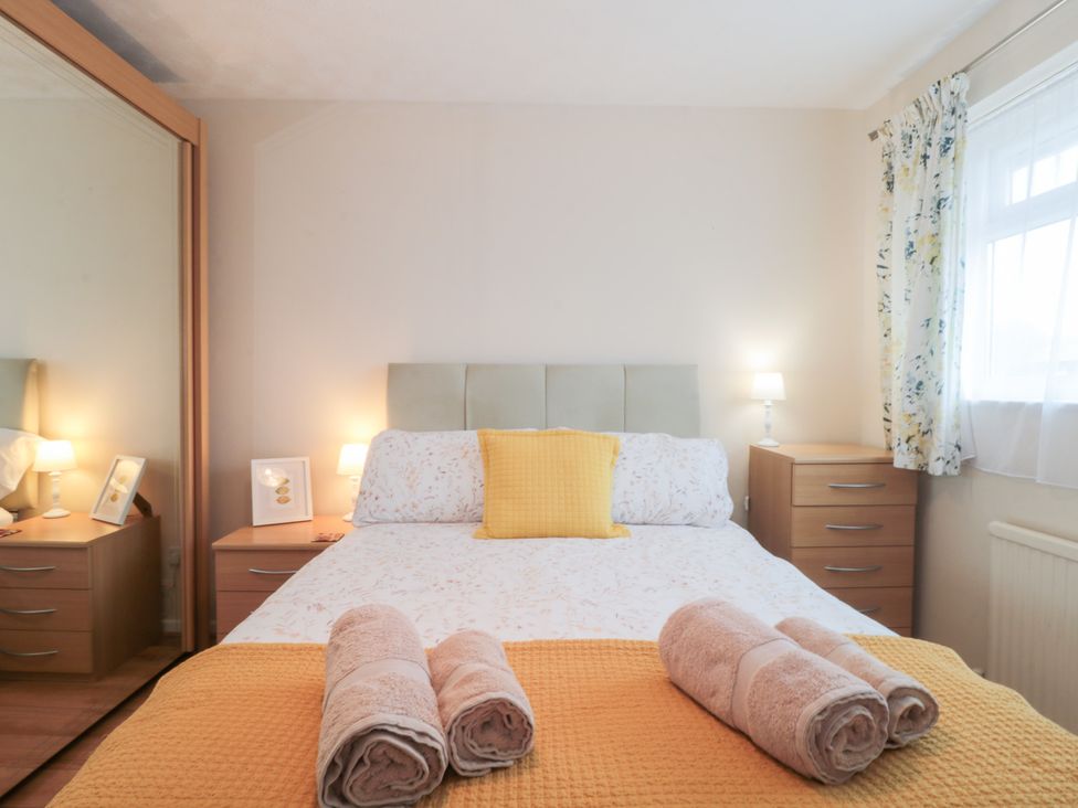 A bedroom with a bed and bedside tables at Jay Cottage in Weymouth