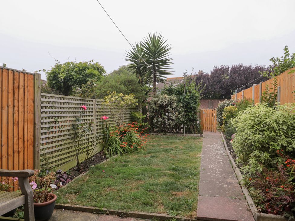 A garden with a path and plants at Jay Cottage in Weymouth